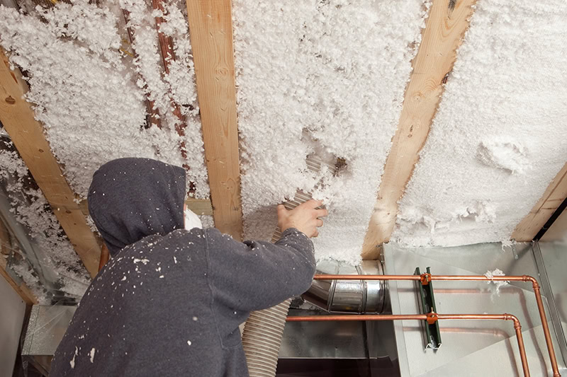 Blown Insulation being Installed between Floor Joists.